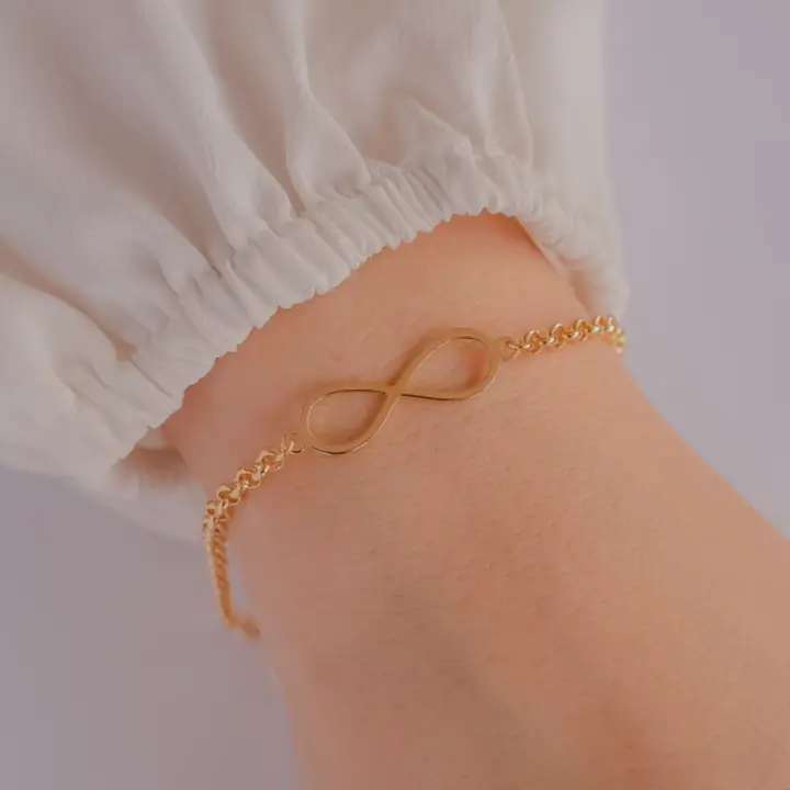 Depois: pulseira infinito banhada, no pulso